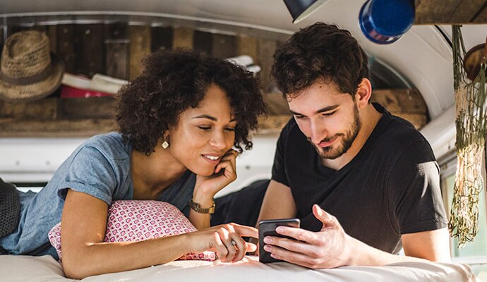 Un homme et une femme regardant un téléphone portable